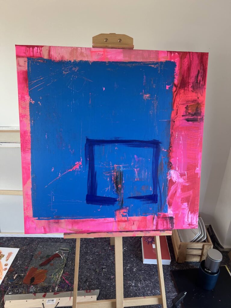 Fortgeschrittener Zwischenstand des Gemäldes »Passform« auf der Holzstaffelei im Atelier mit markantem Blau, Zeichnungen und Pink