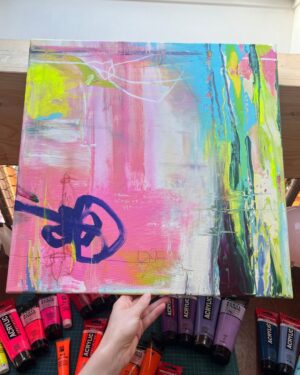 Künstlerin Anika Adam hält das frische Originalgemälde »Gegenlenken« im Atelier über Acrylfarben-Tuben